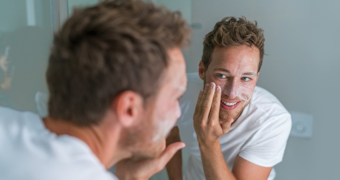 Um homem caucasiano realiza regularmente a esfoliação facial em sua skincare